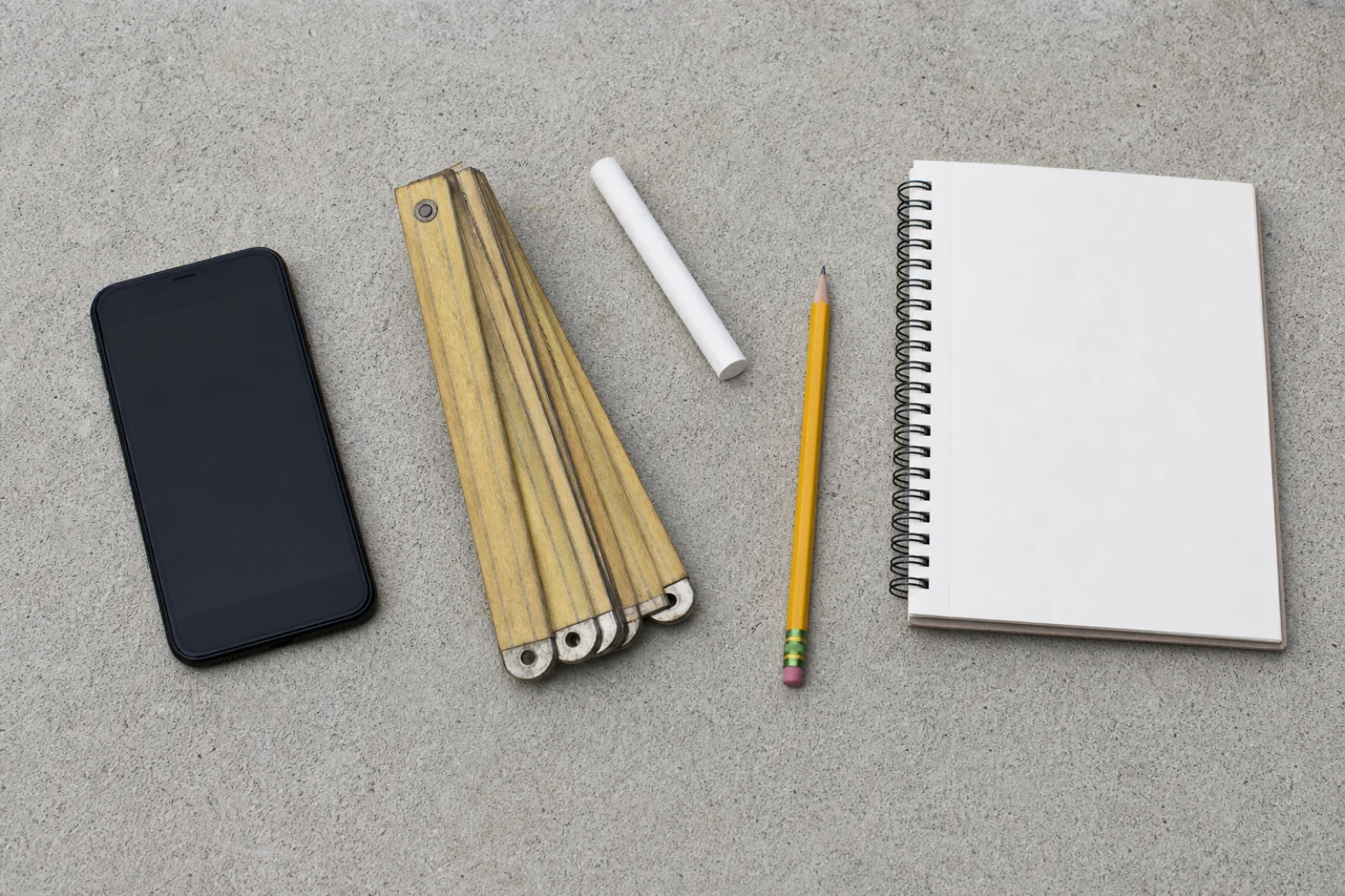 Illustrative phone, folding rule, pencil, chalk, and blank field notebook